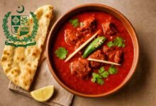 A bowl of Pakistan’s National Dish Nihari served with naan, garnished with ginger, chili, coriander, and lemon.