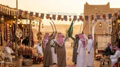 Saudi woman in traditional abaya standing with DSLR camera against the modern Riyadh city skyline during golden hour