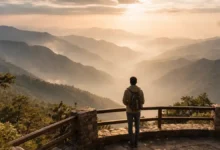 Traveler at a mountain viewpoint overlooking misty Asir Mountains in Abha at sunset