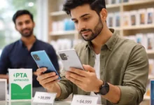 Pakistani shopper comparing two smartphones in a mobile phone shop with PTA approved sign and price tags in rupees.