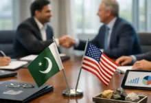 Pakistan and U.S. desk flags on a conference table as delegates shake hands during a diplomatic meeting, symbolizing 2026 relations.