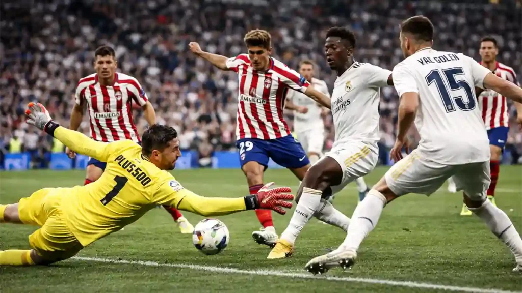 Atlético Madrid goalkeeper dives to stop a close-range Real Madrid shot during a tense match at Santiago Bernabéu