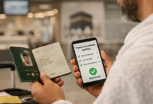 Umrah traveler at a Pakistan airport holding a passport and phone showing travel documents verified in the FIA EMI App Pakistan