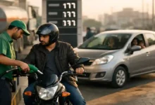 Motorcyclist refueling at a petrol station in Pakistan while a family car waits nearby, showing the daily impact of rising fuel prices.